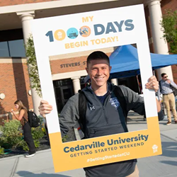 Freshman student smiling outside holding 1000 Days sign.
